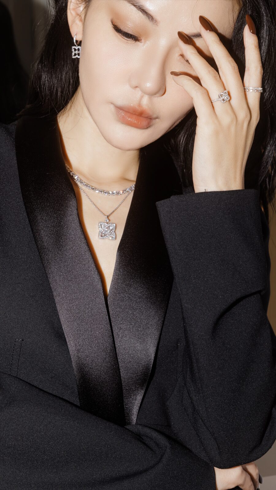Jessica Wang wearing a black blazer with her manicure visible beside her face