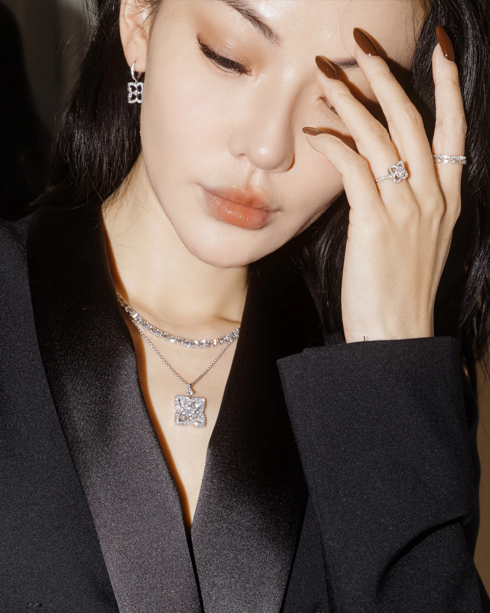 Close-up of Jessica Wang with her eyes closed and four fingertips resting above one eyebrow.