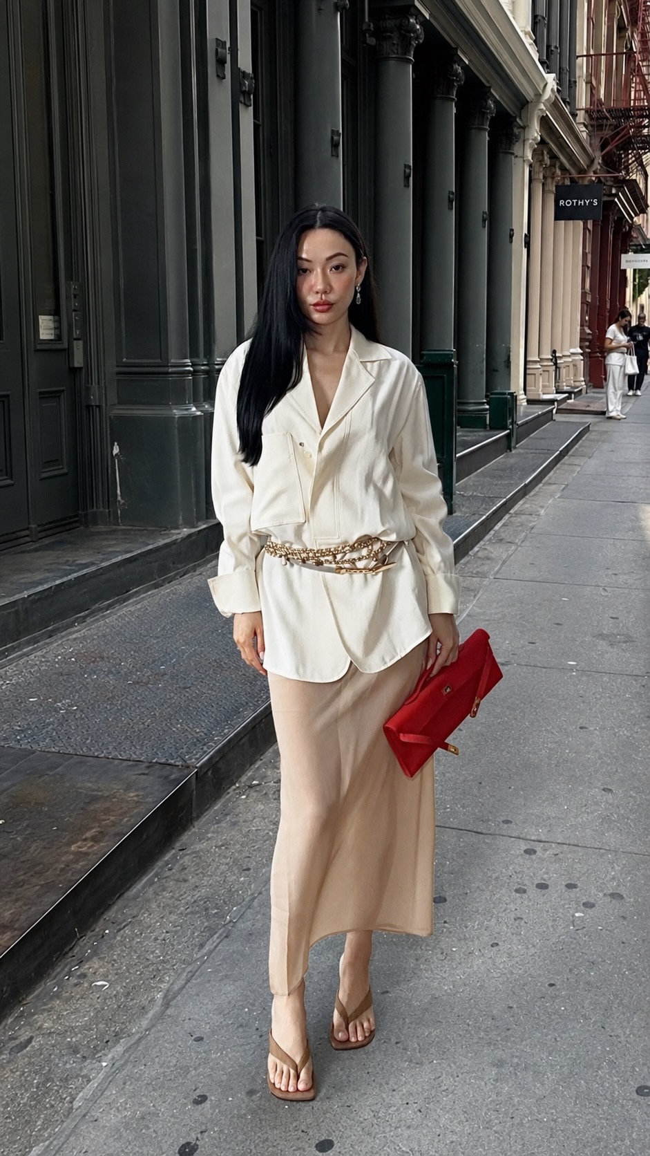 Jessica Wang wearing a structured white shirt with a long beige skirt