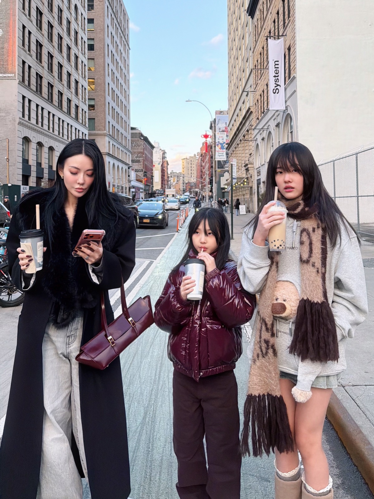 Jessica Wang carrying a structured oxblood satchel with a black coat and gray jeans in New York